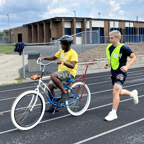 2023 Bike Camp-Session 5-1 youth biking with adapted bike and helper