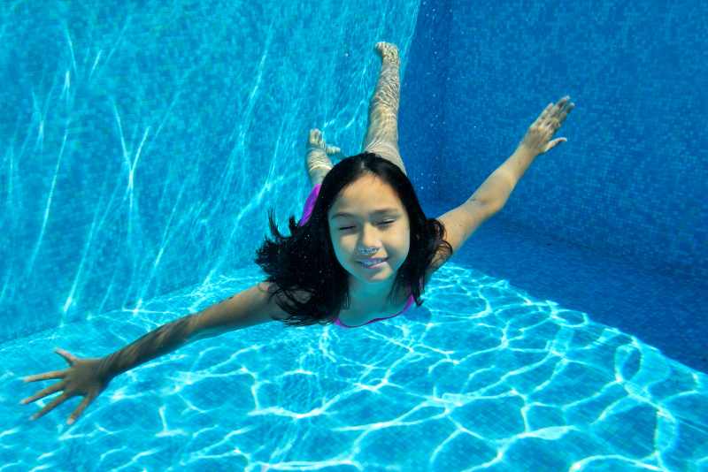 Water Safety Program – Young girl swimming underwater Water Safety Program - Young girl swimming underwater