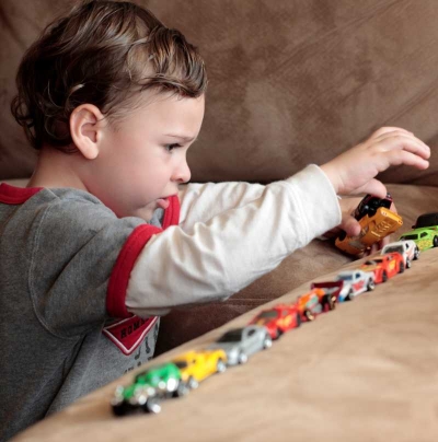 Preschool age boy lining up toy cars