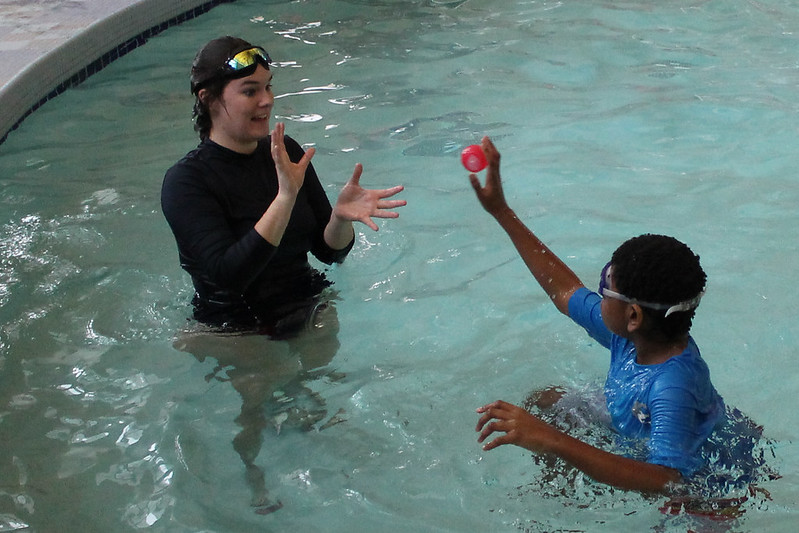 young boy with autism playing ball in a pool learning water safety