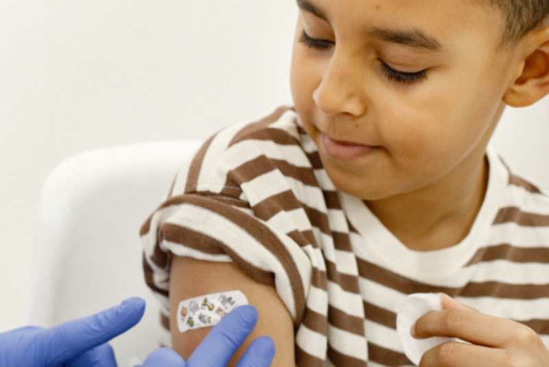 Young boy getting a bandage from a shot